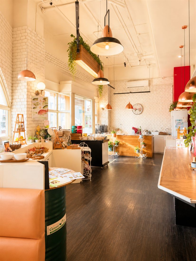 The café interior — white brick, copper pendant lights and a dark wood floor